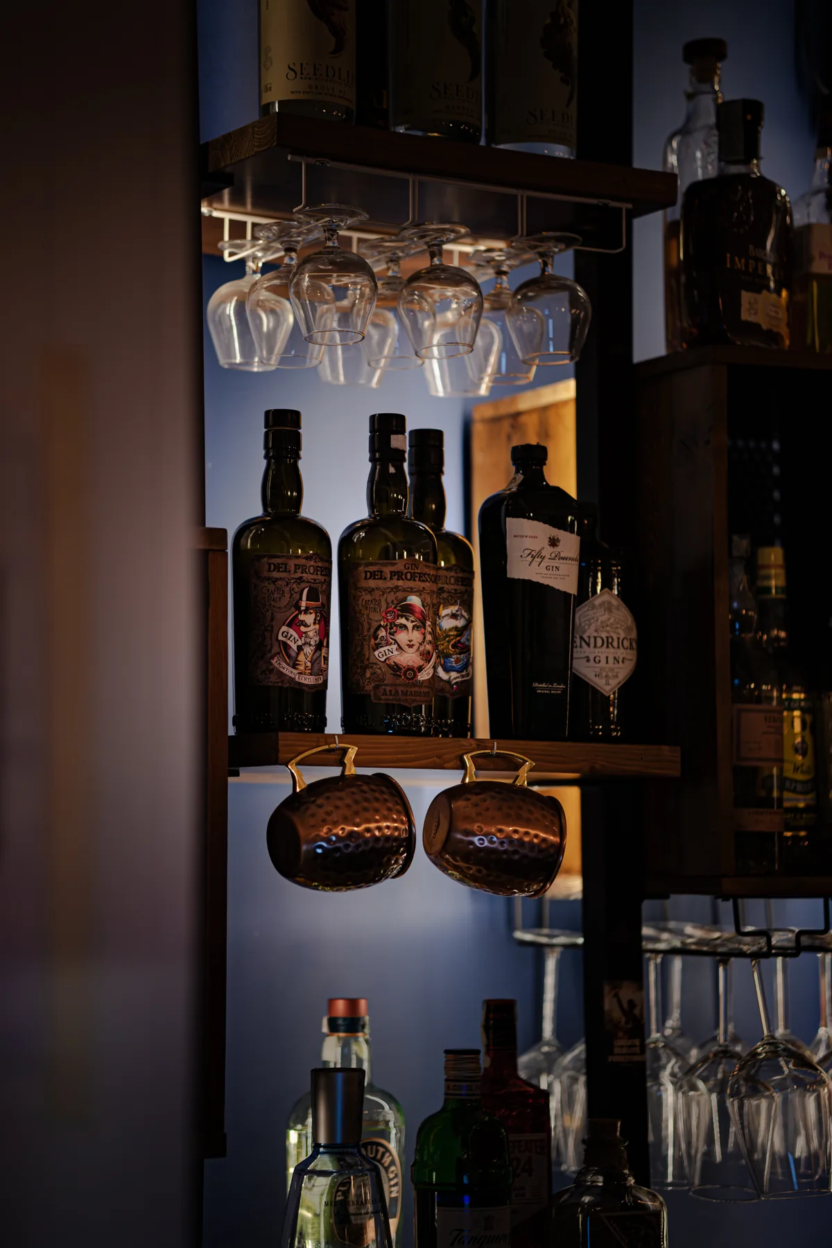 Bottiglie e strumenti da cocktail nella luce del banco di Santé