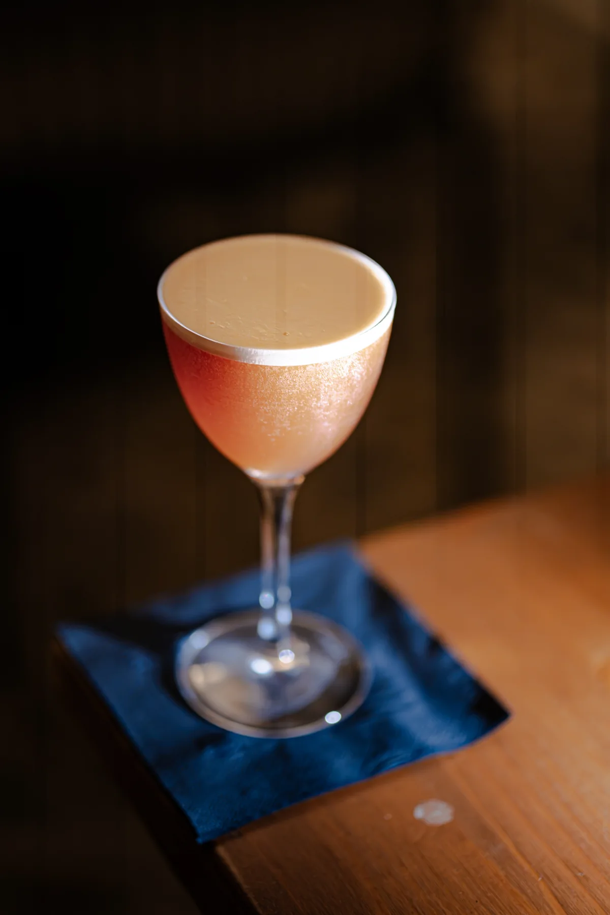 Cocktail in coppa su un sottobicchiere blu di Santé